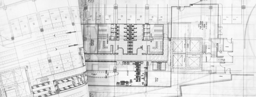 a rolled up blueprints on a table - progetto costruzioni